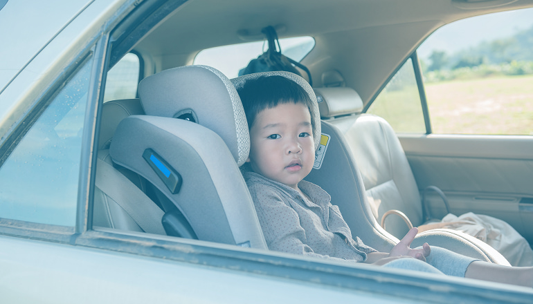 niño pequeño en la sillita del coche, uso correcto de la silla infantil en el coche